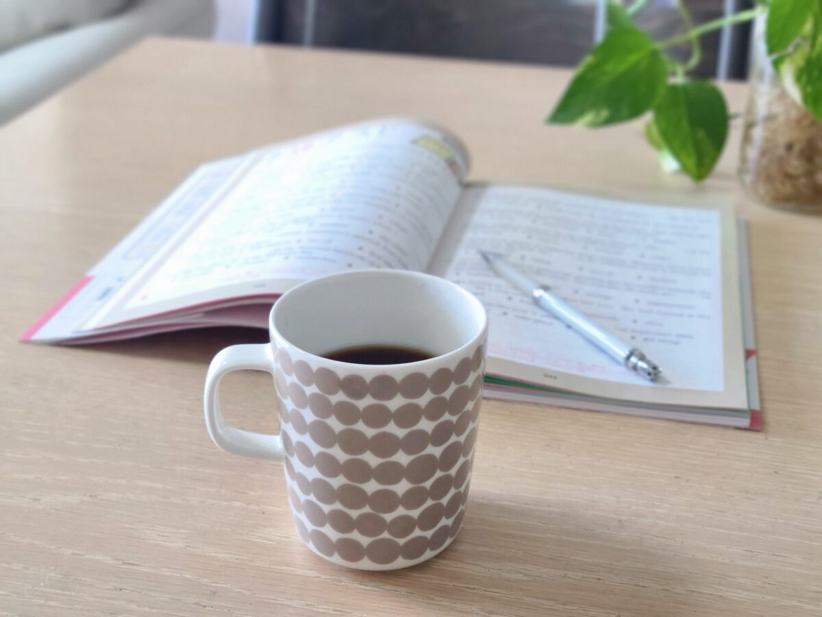 コーヒーと開いたノートがある静かな朝の風景