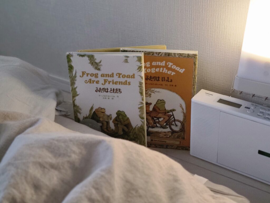 暗く灯りをともした部屋に布団と英語絵本とCDプレイヤーが置いてある風景