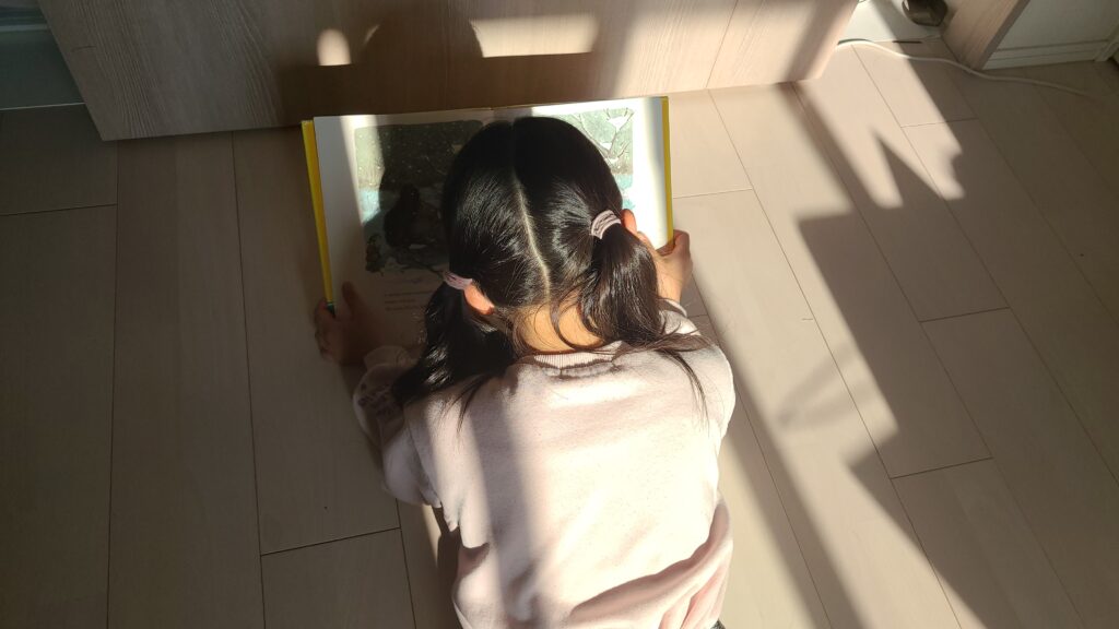 娘がてぶくろを読んでいる写真