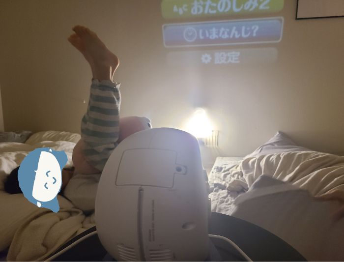 娘が寝室で寝転がってドリームスイッチをみているいる写真