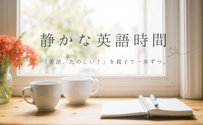 窓辺にある木の机にノート・親子で使う大きさ違いのコップが２つあり、明かるい光がさしこんでいる。珊瑚色の花が活けてある風景の写真に、「親子で一歩ずつ　心と英語を静かに整えるひととき」と書いてある。
